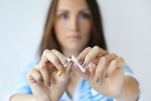 Portrait of young woman refuses to smoke and breaks cigarette.