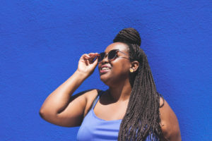 Woman with sunglasses on smiling in front of building