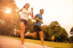 Man and woman  jogging outdoors in the park.